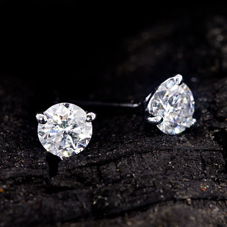 Two eye catching white gold diamond studs on top of black rock.